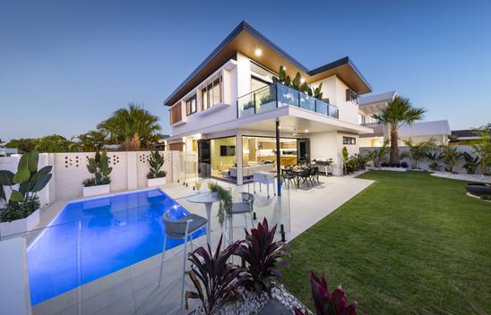 An outdoor dining area set out for 6 overlooking the living Area and a pool