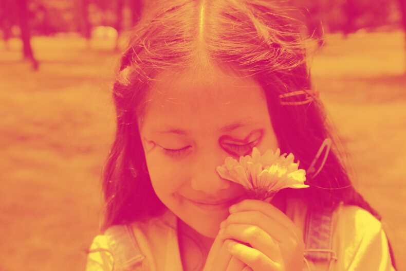 Young girl smiling with flower