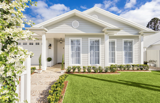 A single level home with a gated arbor trellis with jasmine and white picket fence.