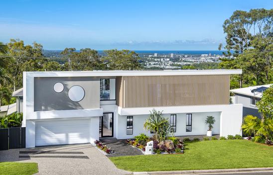 External shot of a two story house with a garage and garden.